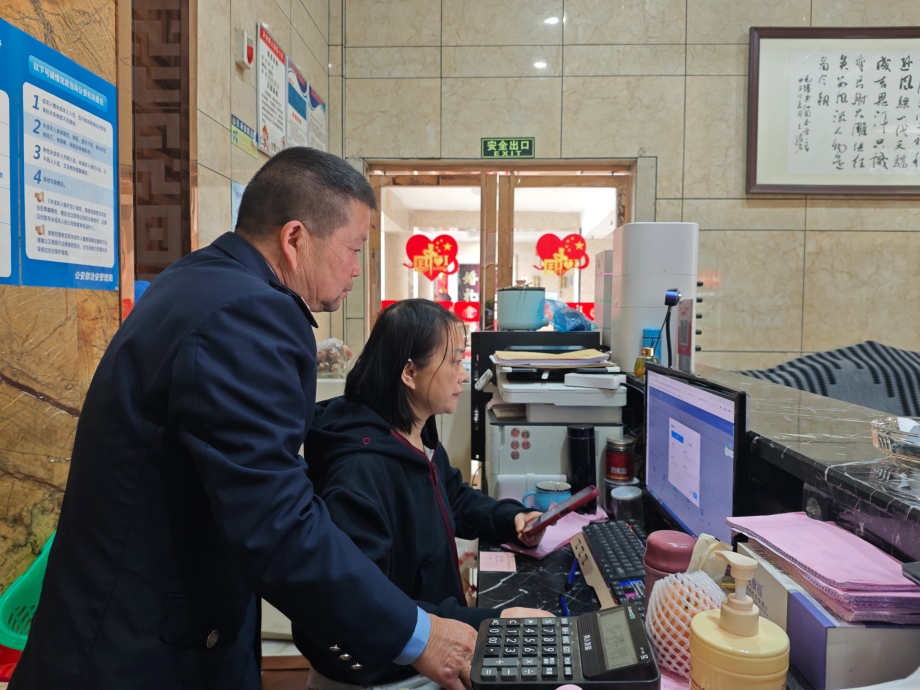 图为税务干部辅导商家操作电子税务局.jpg 图为税务干部辅导商家操作电子税务局.jpg