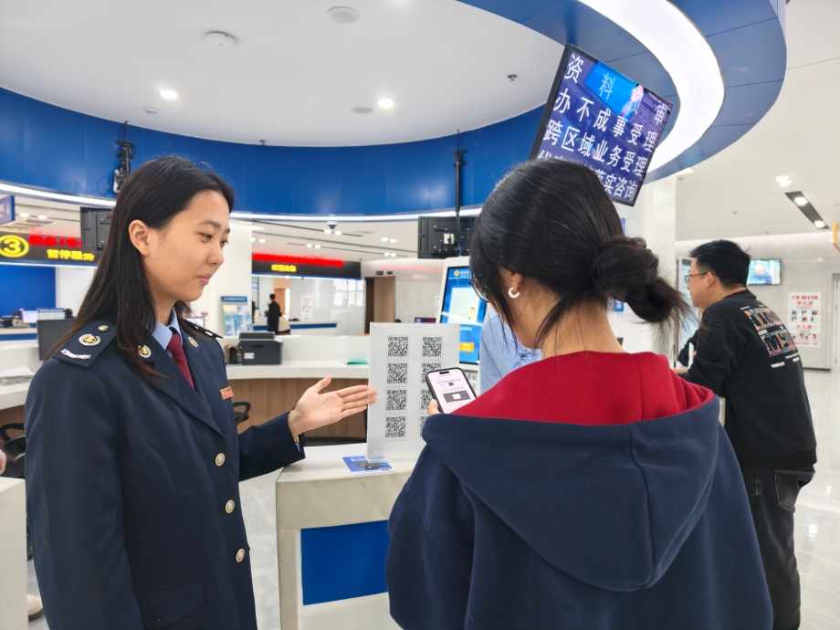 图为税务干部辅导纳税人扫码办税。1.jpg 图为税务干部辅导纳税人扫码办税。1.jpg